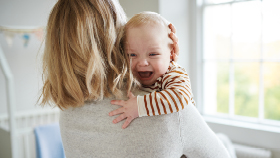 Mutter hält weinendes Baby auf dem Arm