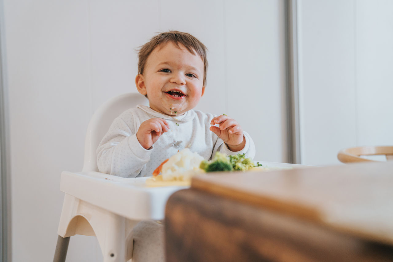 Baby im Hochsitz am essen