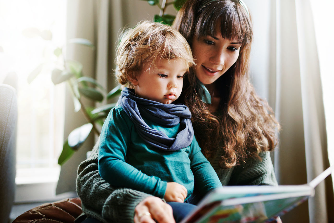 Mutter liest Kleinkind aus Buch vor