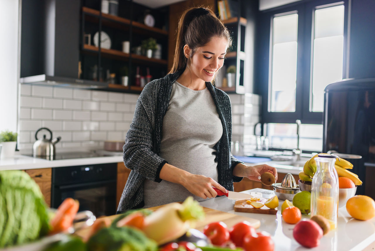 Schwangere bereitet Essen zu