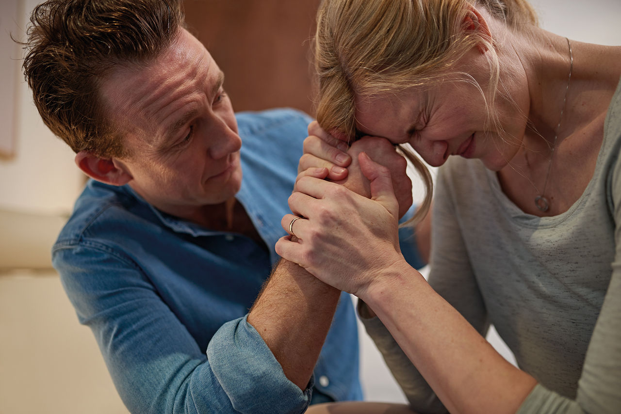 Frau in den Wehen hält sich an Partner fest